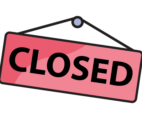 A traditional shop door sign saying "closed": black text on pink