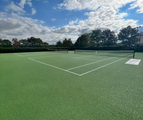 Resurfaced green tennis courts on a sunny day